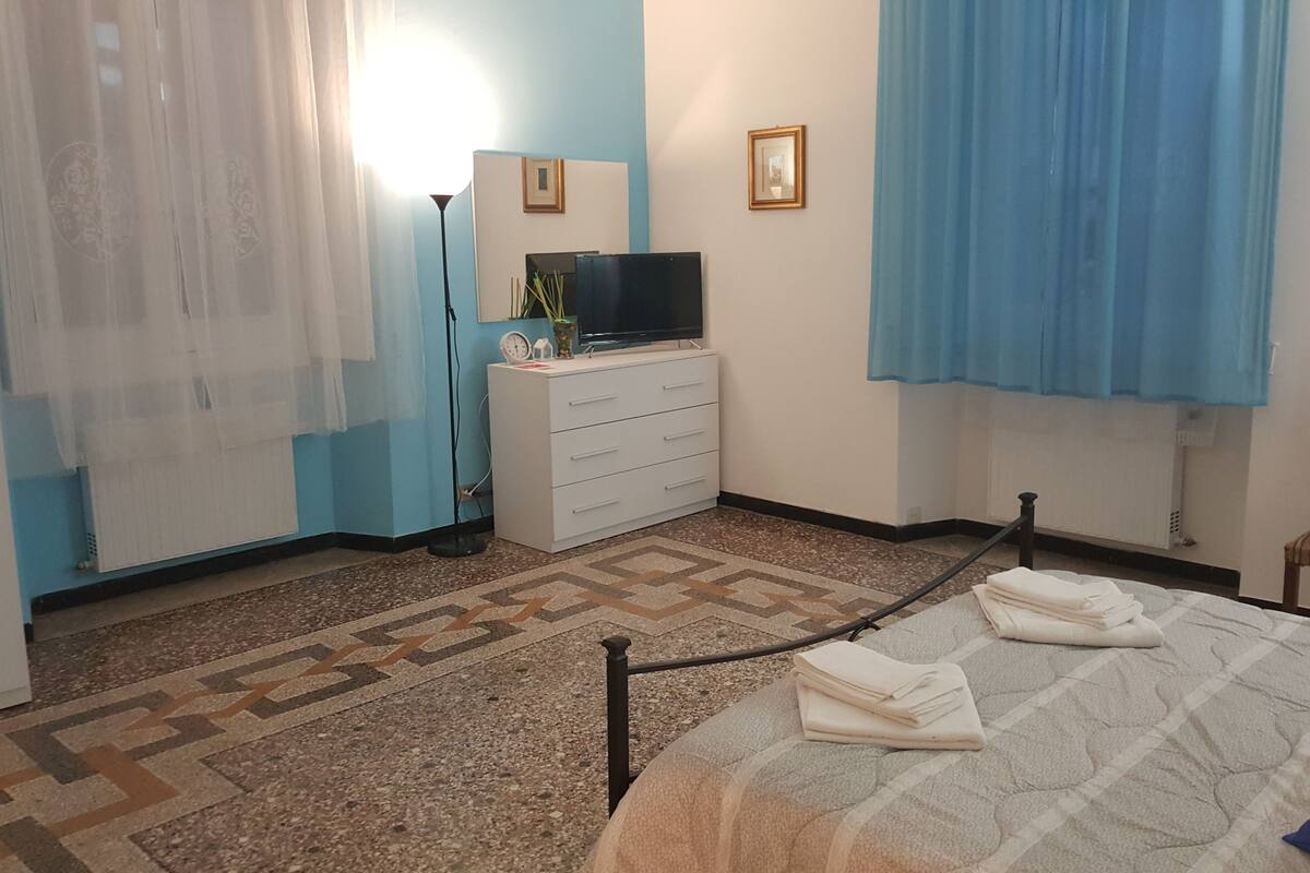 A hotel room with a bed, a dresser, a television, and a chair.