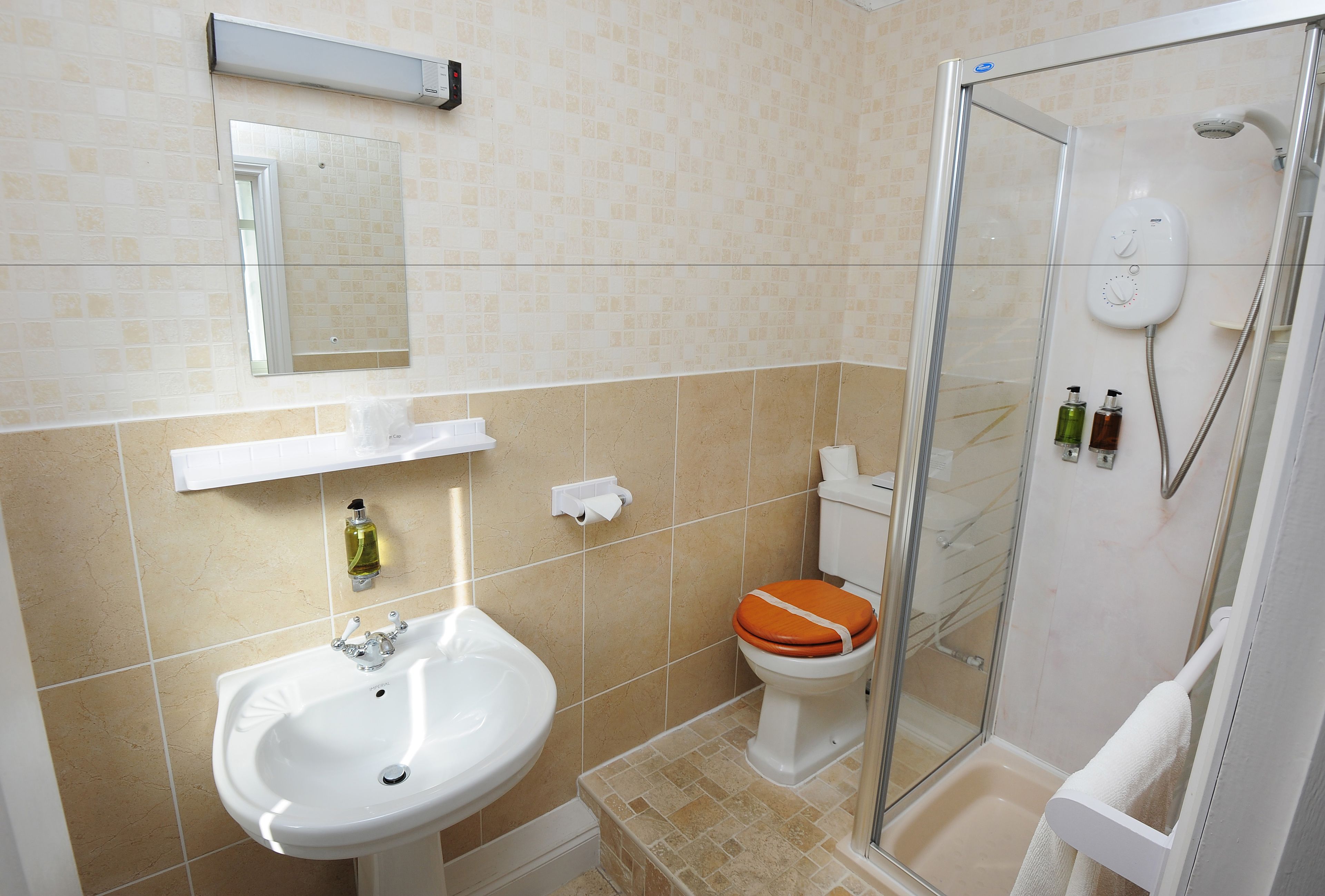 A bathroom with a sink, toilet, and glass-enclosed shower.