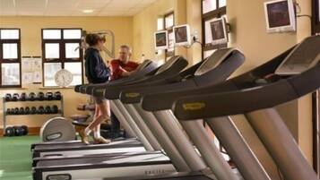 A gym with treadmills, a weight rack, and a scale.