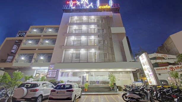 A multi-story building with a cafe on the top floor, featuring a modern design with large windows and a visible staircase leading to the entrance. - Treebo Lalaji's Executive (Chhatrapati Sambhajinagar)