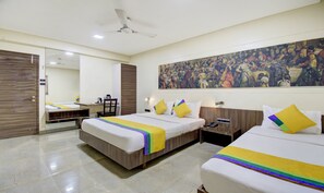 Habitación de hotel con dos camas, un escritorio y un cuadro grande en la pared.