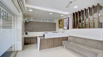 A reception area with a reception desk, a sofa, a clock, and a framed photo on the wall.