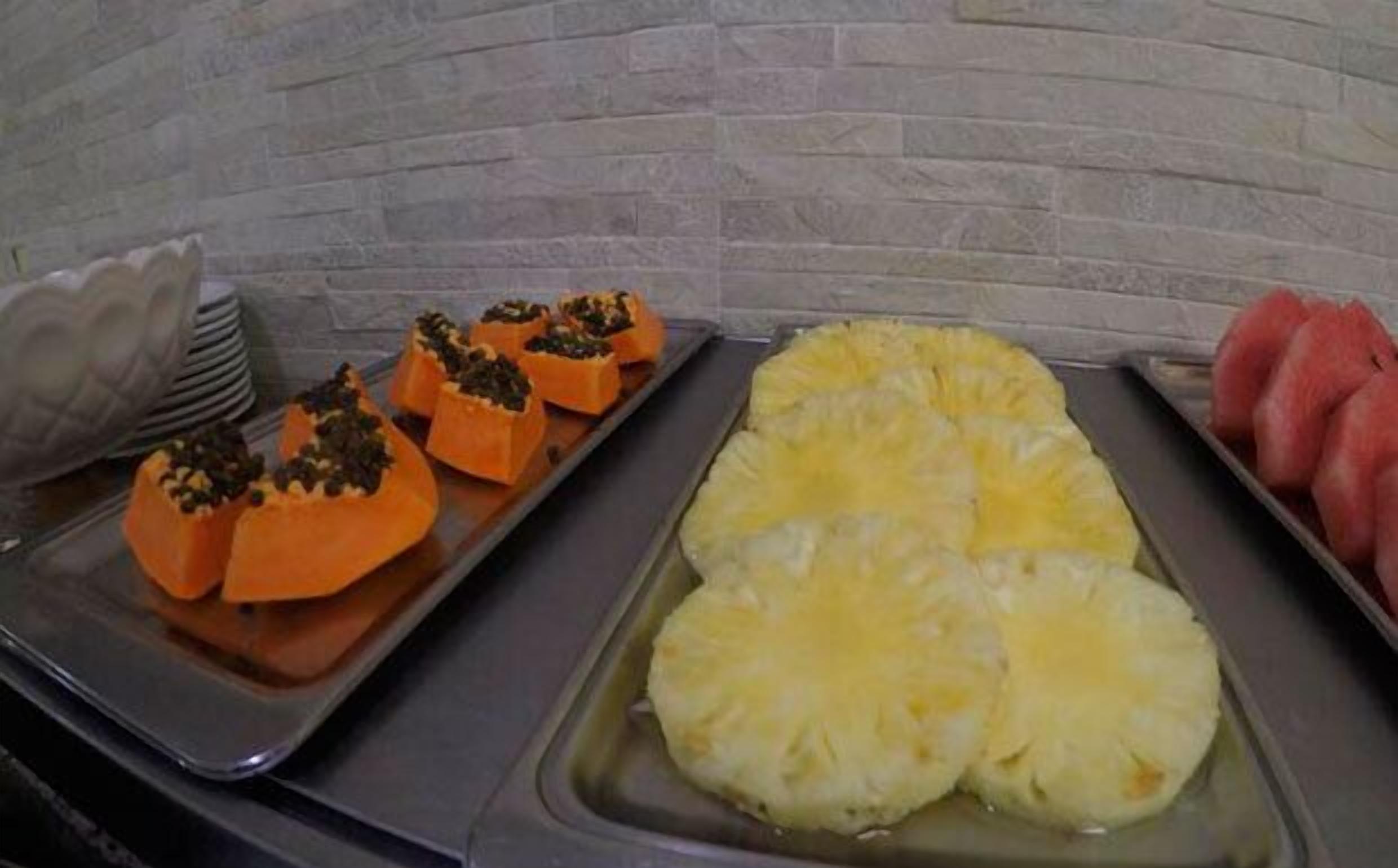 A buffet with sliced pineapple and stuffed sweet potatoes.