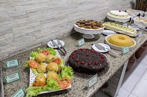 Un bufé con diversos postres y comidas, incluyendo un pastel de chocolate y un pastel bundt.