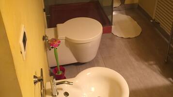 Un baño con inodoro, bidé y lavamanos.