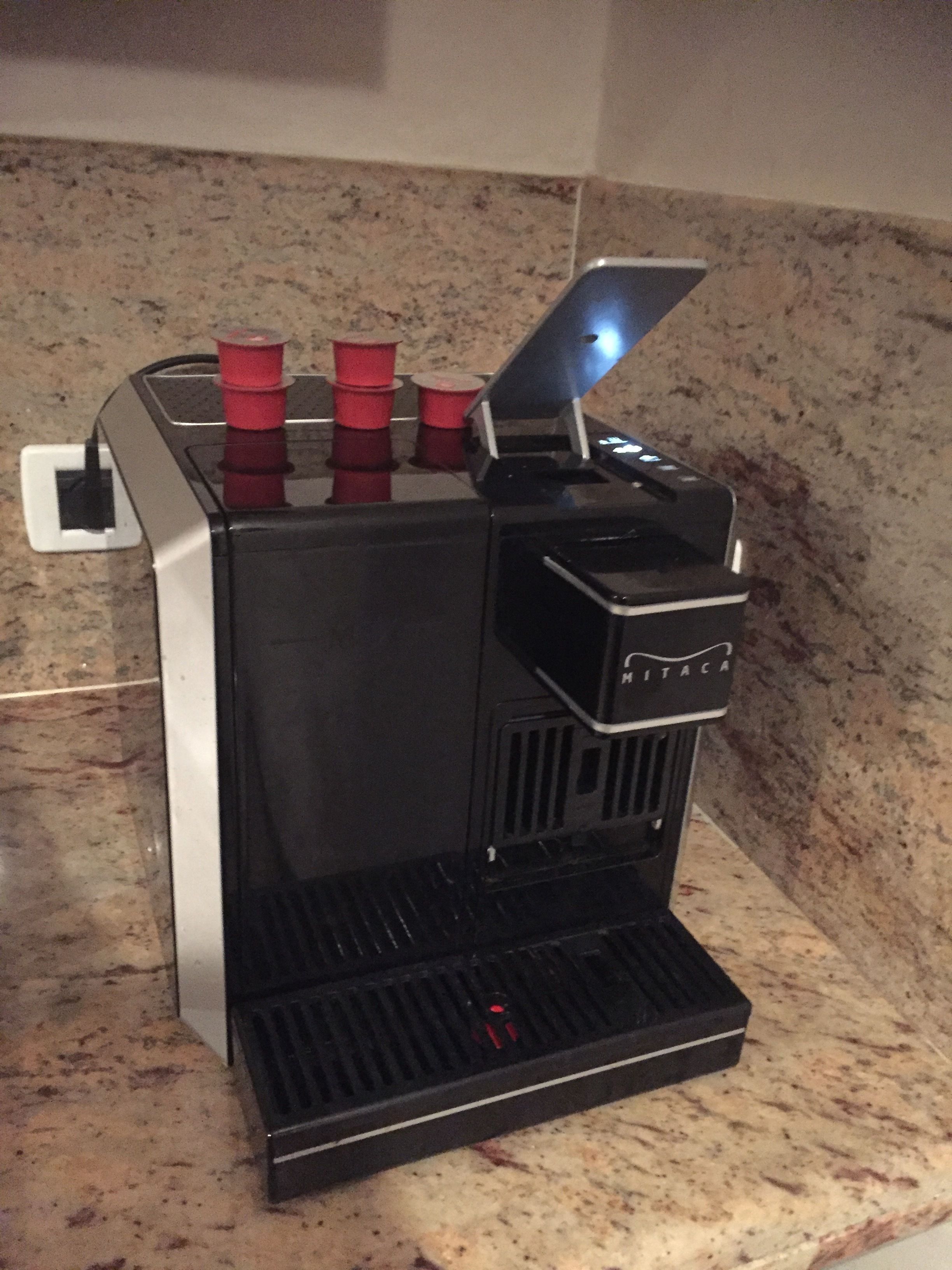 A coffee machine with a digital display and a small tray.
