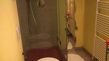 Un baño con ducha, inodoro y lavamanos.
