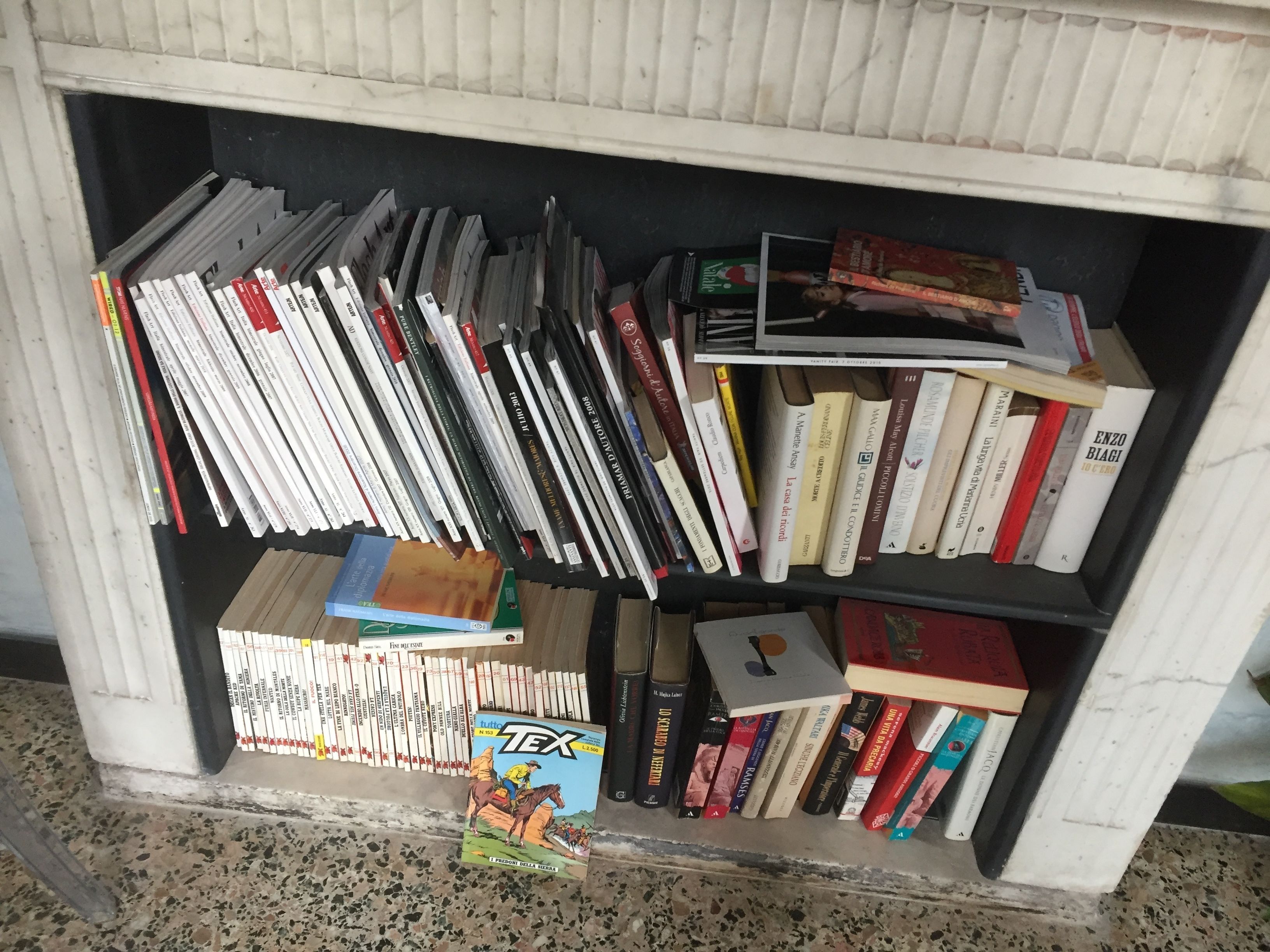 A bookshelf filled with various books, including some with visible titles and authors.