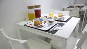 A breakfast table with croissants, coffee, juice, and a croissant on a plate. - Tiburtina Royal Suites (Rome)