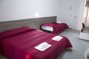 A hotel room with two beds, each with a red bedspread and white towels. - Tiburtina Royal Suites (Rome)