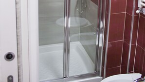 A glass-enclosed shower stall with a handheld showerhead and a handheld faucet. - Tiburtina Royal Suites (Rome)