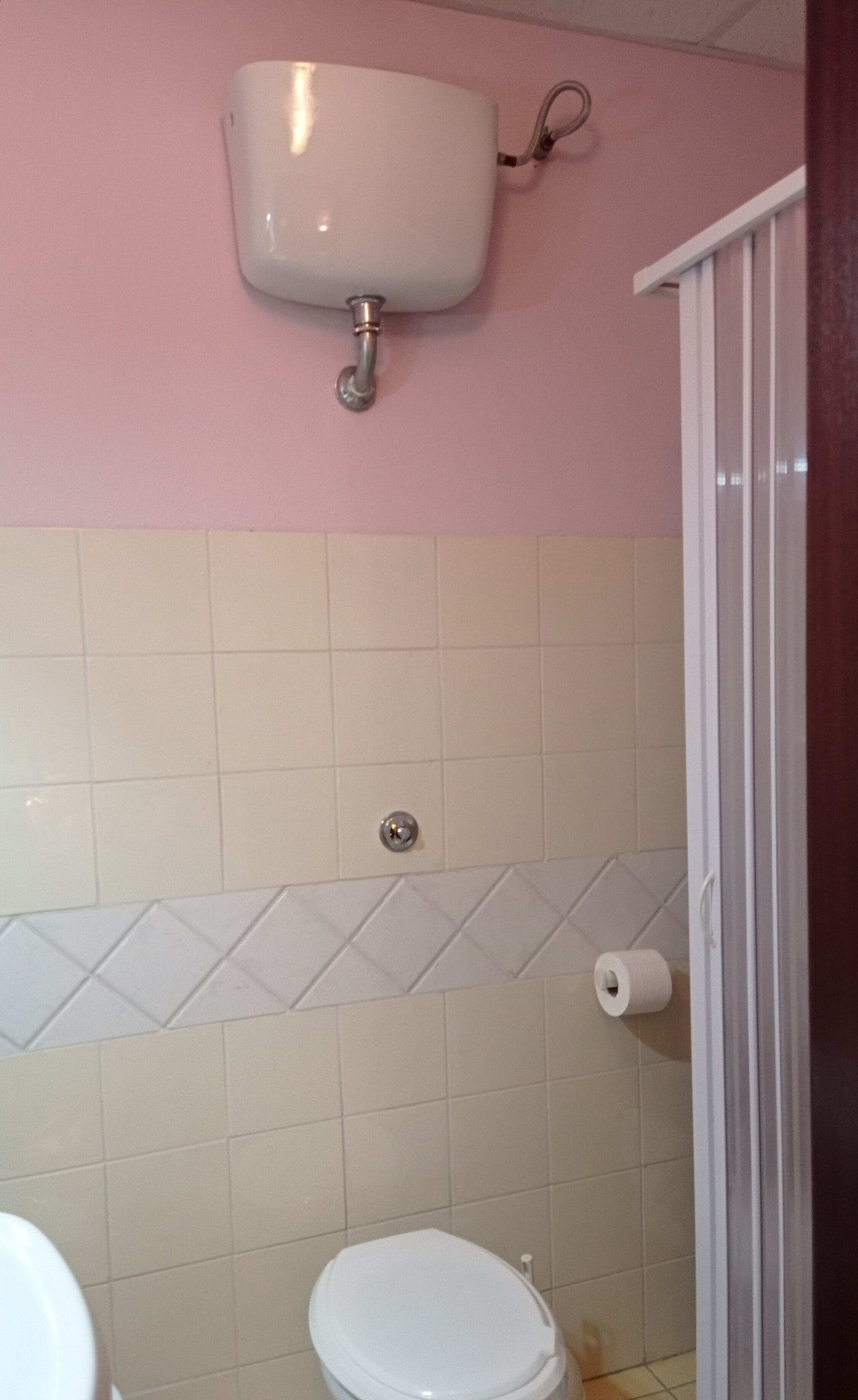 Une salle de bain avec des toilettes, un lavabo et une douche.