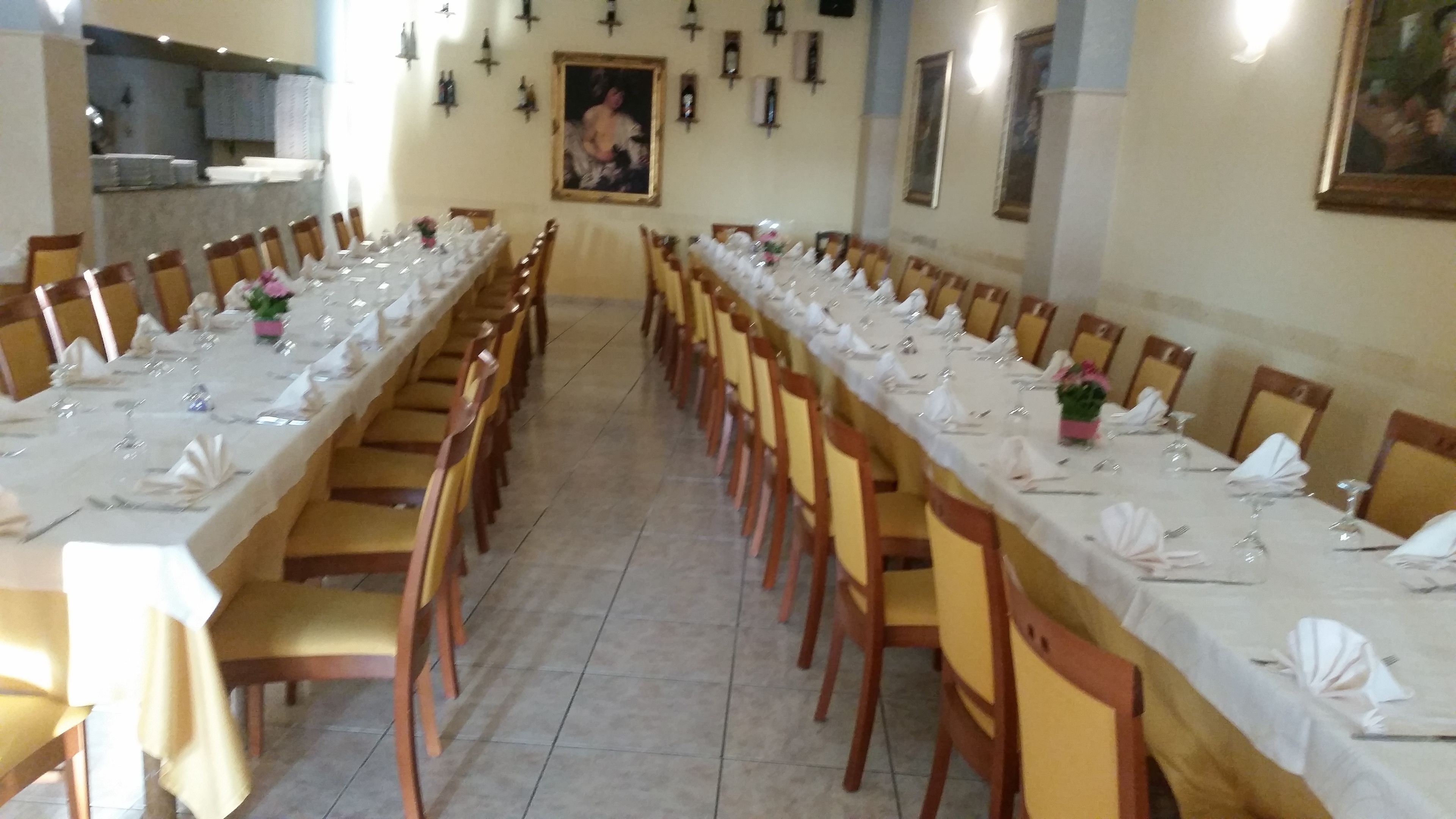 A long dining table set for a formal event, with chairs on both sides.