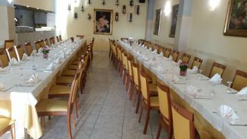 A long dining table set for a formal event, with chairs on both sides.