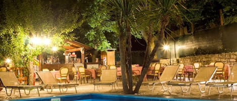 Una piscina al aire libre de temporada, sombrillas