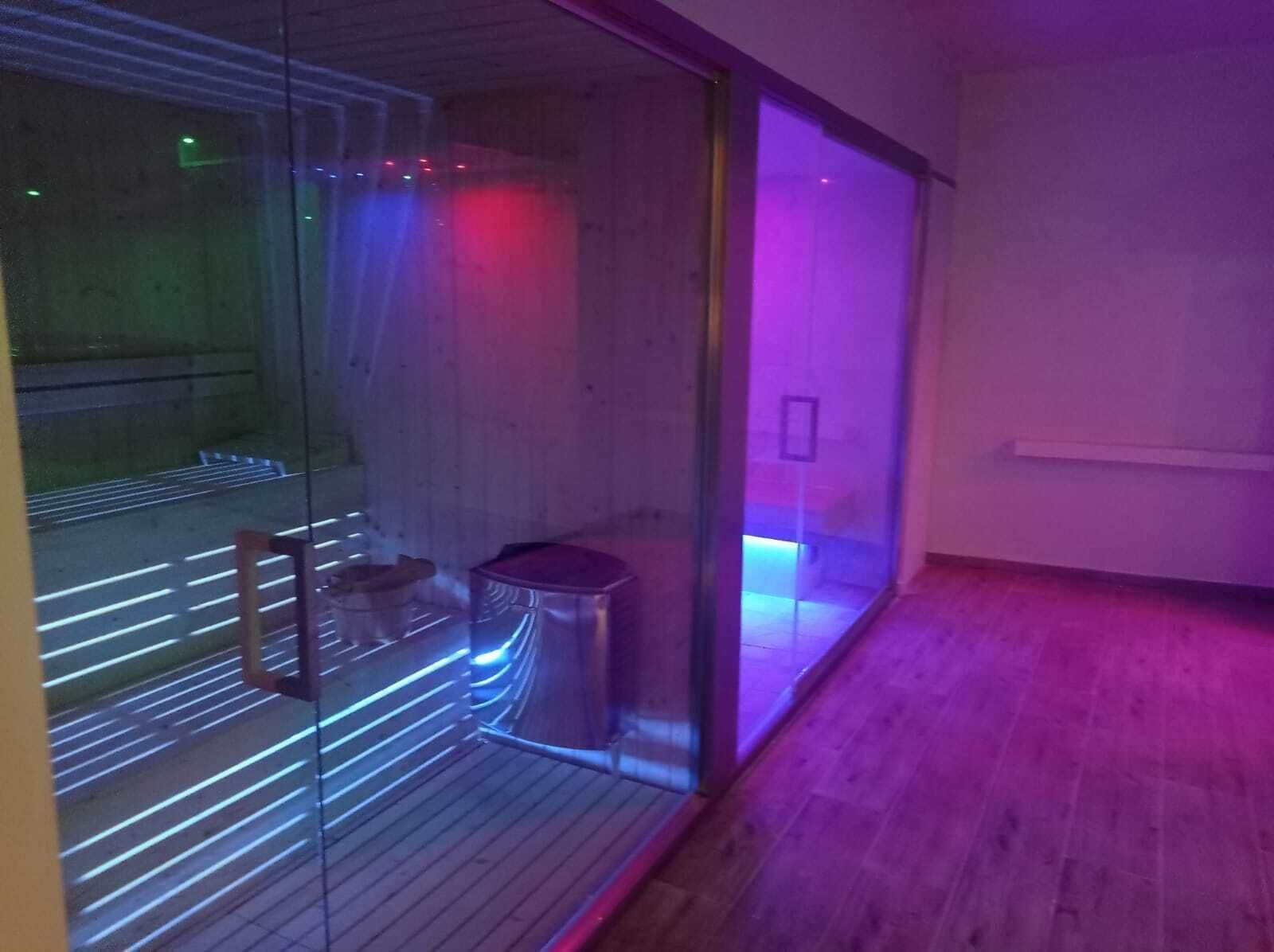 A room with a glass partition, a wooden floor, and a metal trash bin.