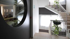 Un interior espacioso con una escalera, un espejo grande y vistas a un comedor.