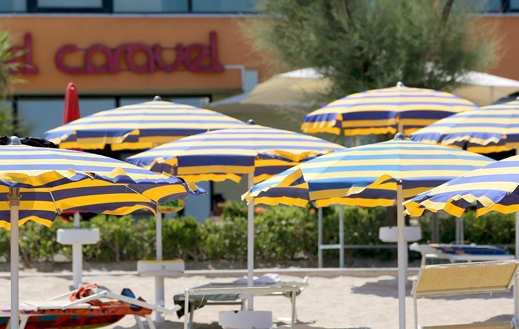 Een strandgedeelte met gestreepte parasols en ligbedden.
