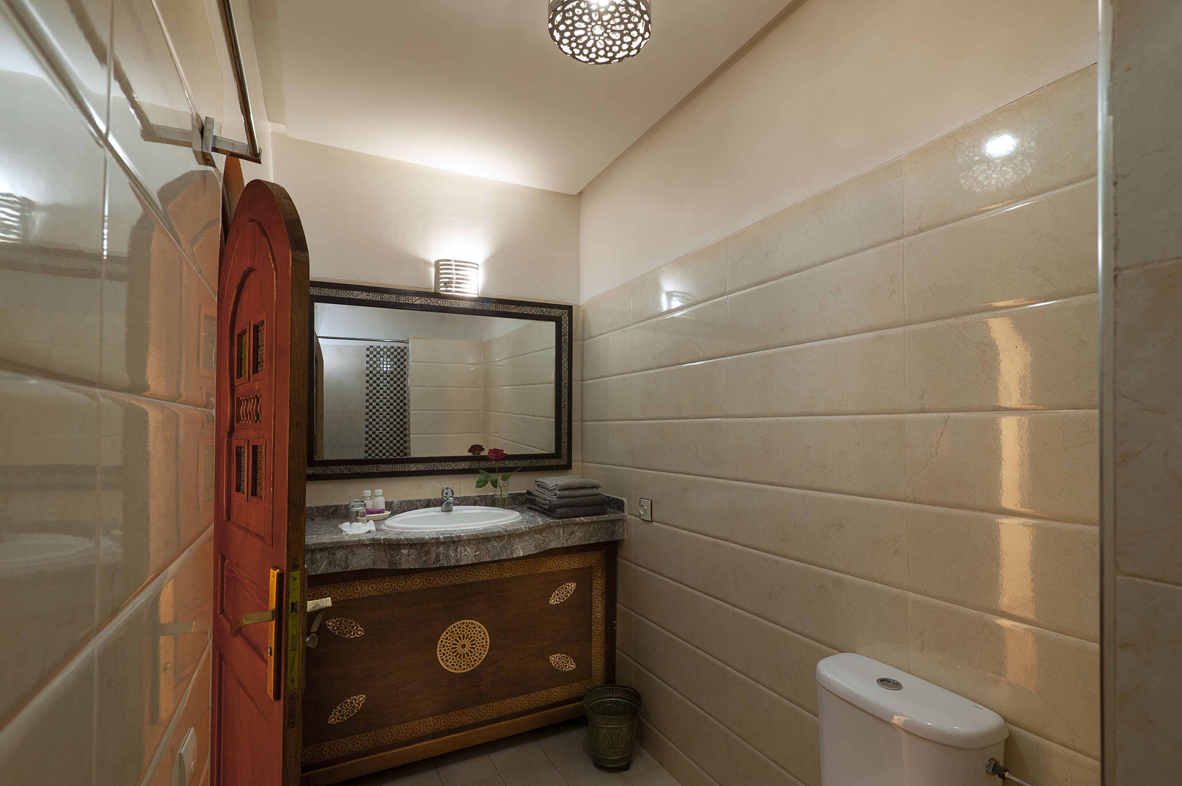 Une salle de bain équipée d’un lavabo, d’un miroir, d’un meuble-lavabo et de toilettes.