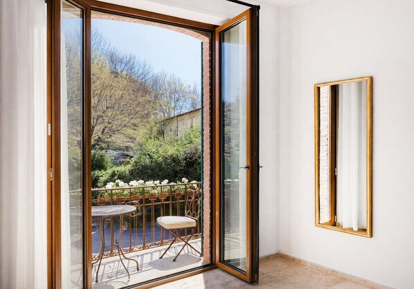 A room with a sliding glass door leading to an outdoor area with a table and chairs. - Villa Marina - Como Lake (Bellano)