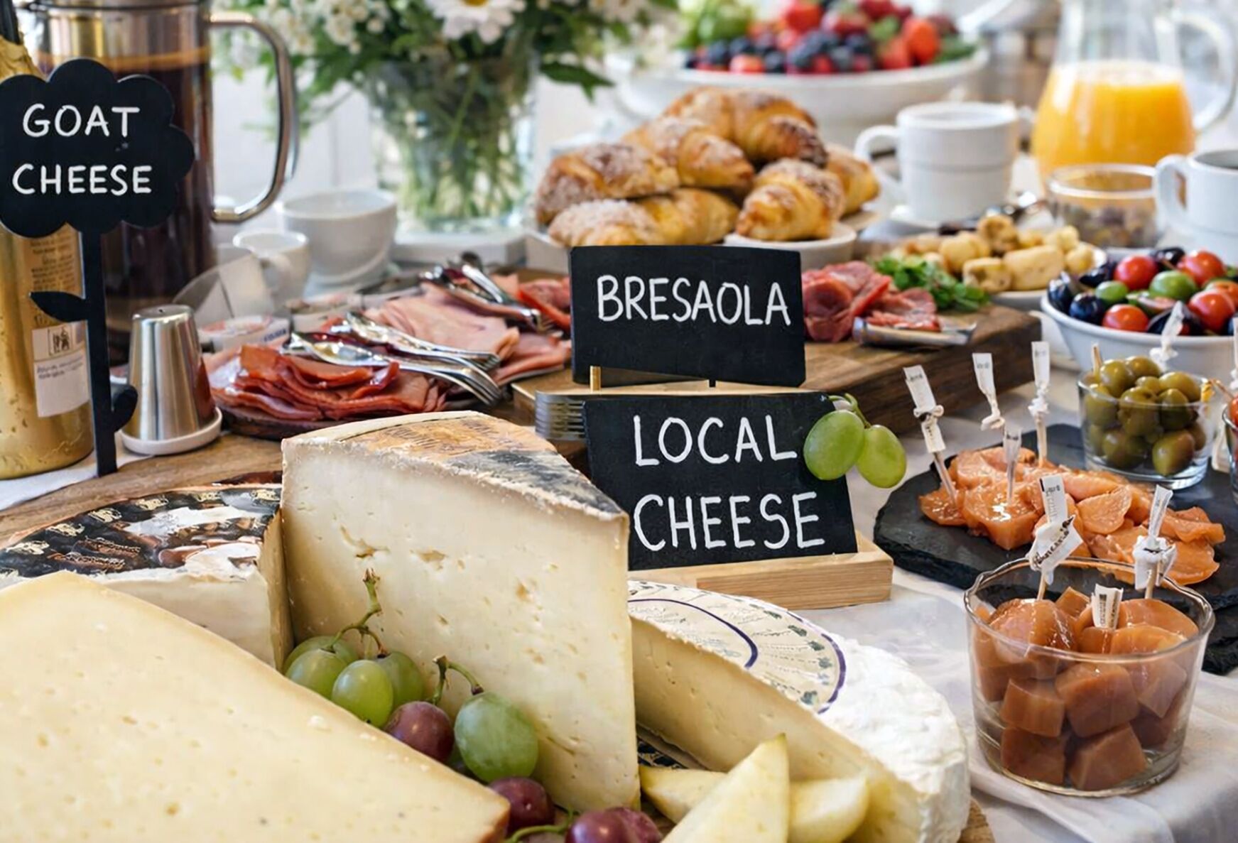Ein reichhaltiges Frühstücksbuffet mit Käse, Obst und Gebäck.