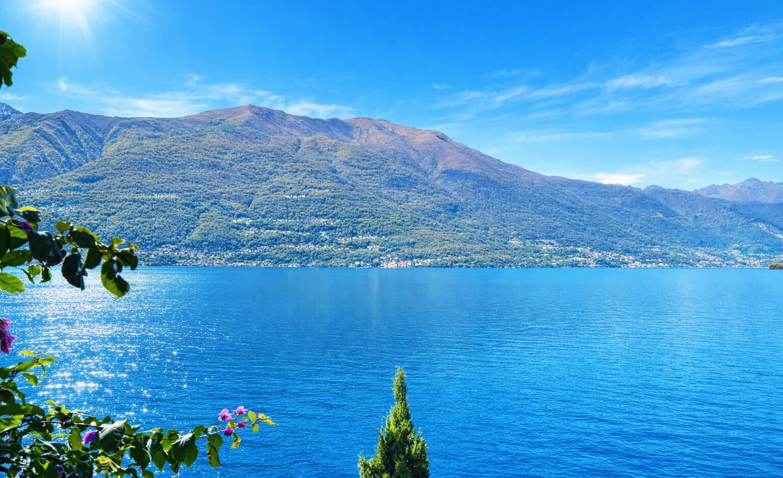 Un lac avec des montagnes en arrière-plan et un ciel dégagé.