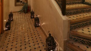 Una escalera con barandillas ornamentadas y baldosas estampadas.
