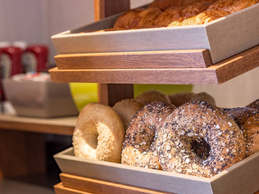 A bakery display with various baked goods and a coffee station in the background.