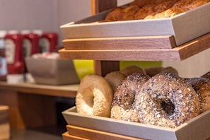 A bakery display with various baked goods and a coffee station in the background.