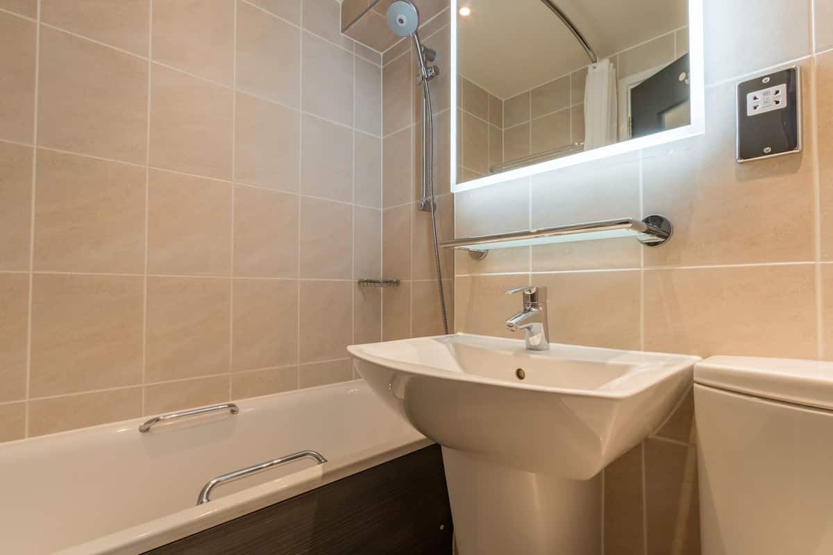 A modern bathroom with a bathtub, a sink, and a toilet.