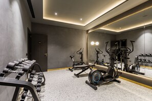 A gym with exercise equipment, a mirror, and a door.