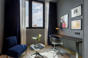A modern room with a desk, chair, and a vase with flowers.