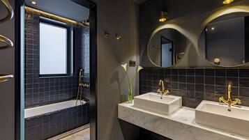 A modern bathroom with a bathtub, two sinks, and a large mirror.