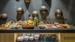 Un buffet proposant une variété de plats et un mur décoré d’objets sphériques.