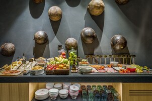 Un buffet con diversi cibi e una parete decorata con oggetti sferici.