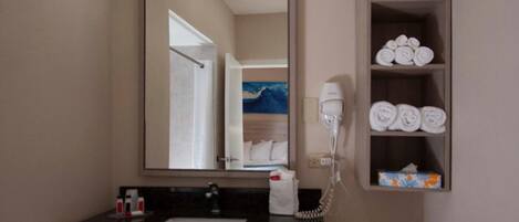 A bathroom with a sink, mirror, towel rack, and a hairdryer.