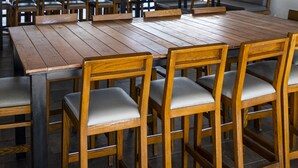 A restaurant with wooden tables and chairs, a blue ceiling, and hanging light fixtures. - Punta Borinquen Resort (Aguadilla)