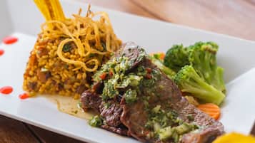 A plate of food with a piece of meat, rice, and vegetables.