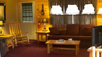 A cozy living room with a wooden rocking chair, a sofa, and a coffee table.