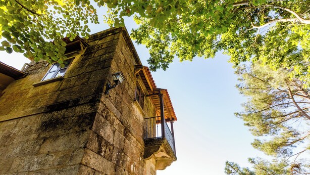 A stone building with a balcony and a window. - Rectoral de Fofe (Covelo)