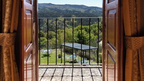 An open balcony with a view of a green landscape and a table with chairs. - Rectoral de Fofe (Covelo)