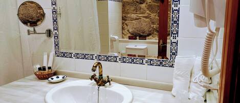 Baño con lavamanos blanco, espejo y toallero.