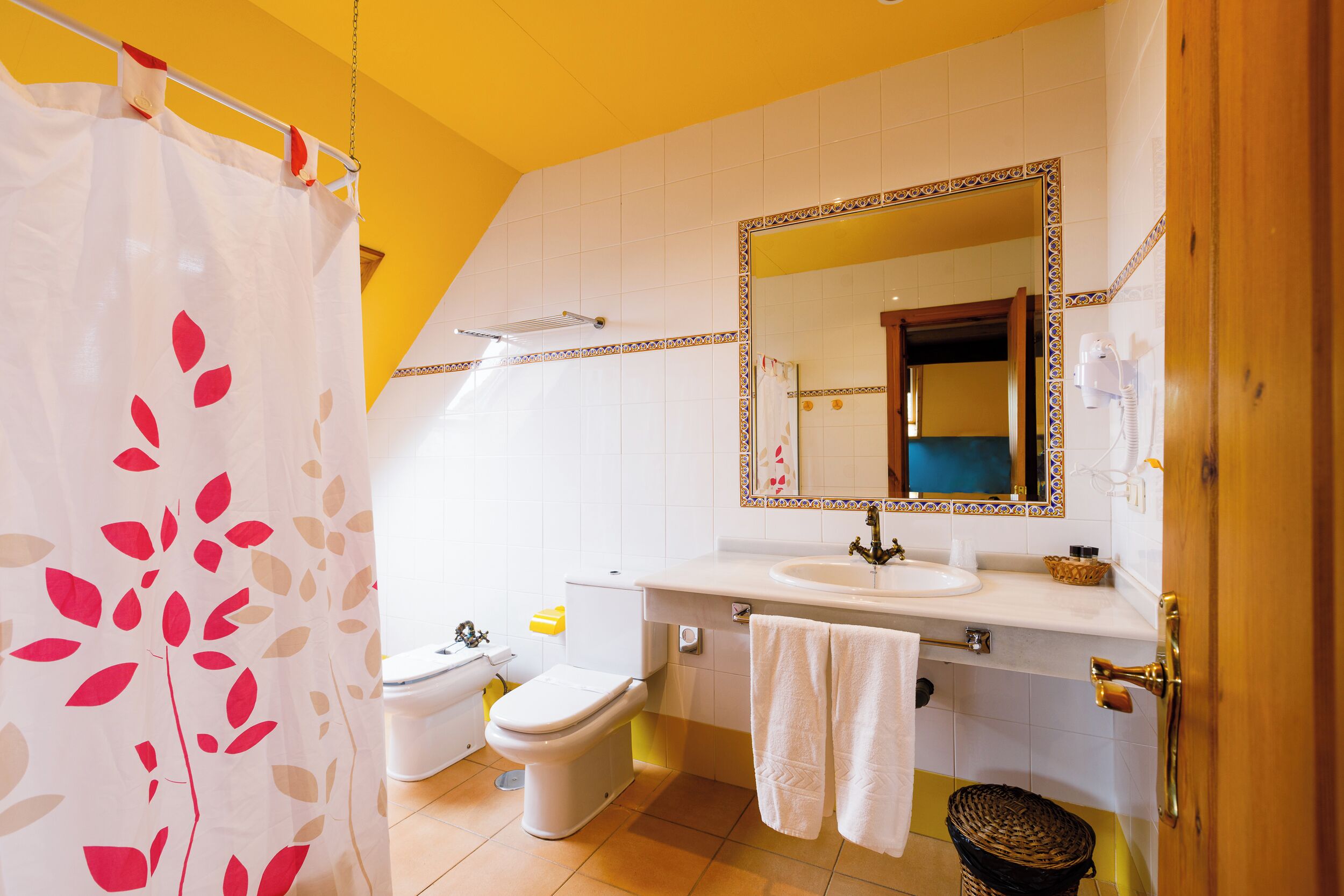 A bathroom with a toilet, sink, and mirror.