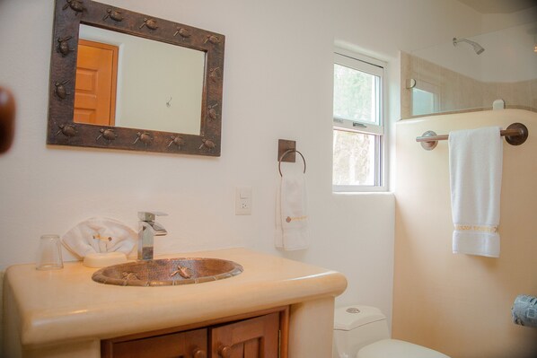 A bathroom with a sink, mirror, towel rack, and toilet.