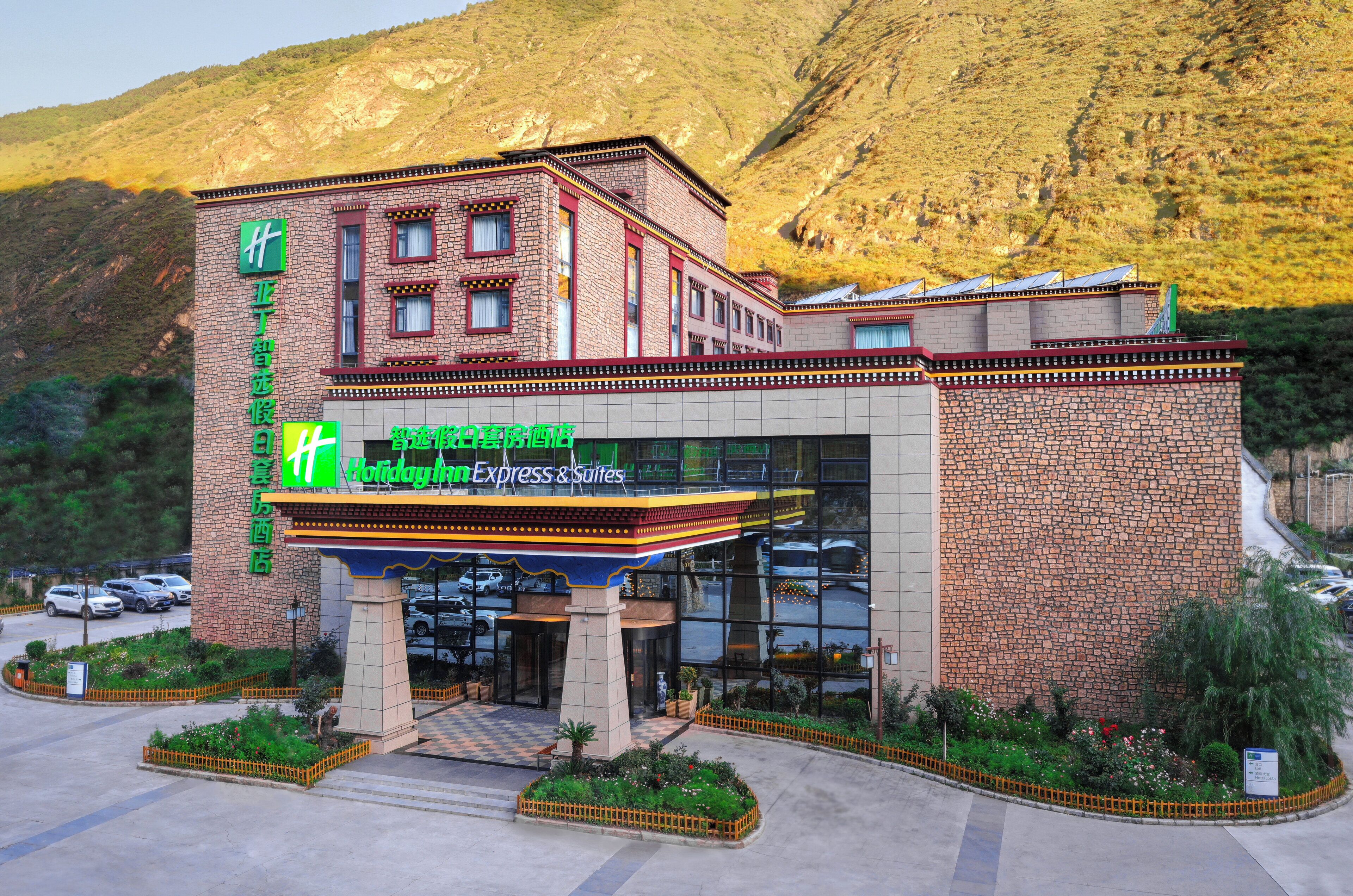 Um hotel com fachada de pedra e um letreiro luminoso para Holiday Inn Express & Suites.