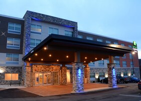 Edificio de Holiday Inn Express con entrada cubierta, fachada de piedra y varias ventanas.