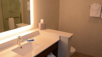 A bathroom with a white sink, a mirror, a towel rack, and a toilet.