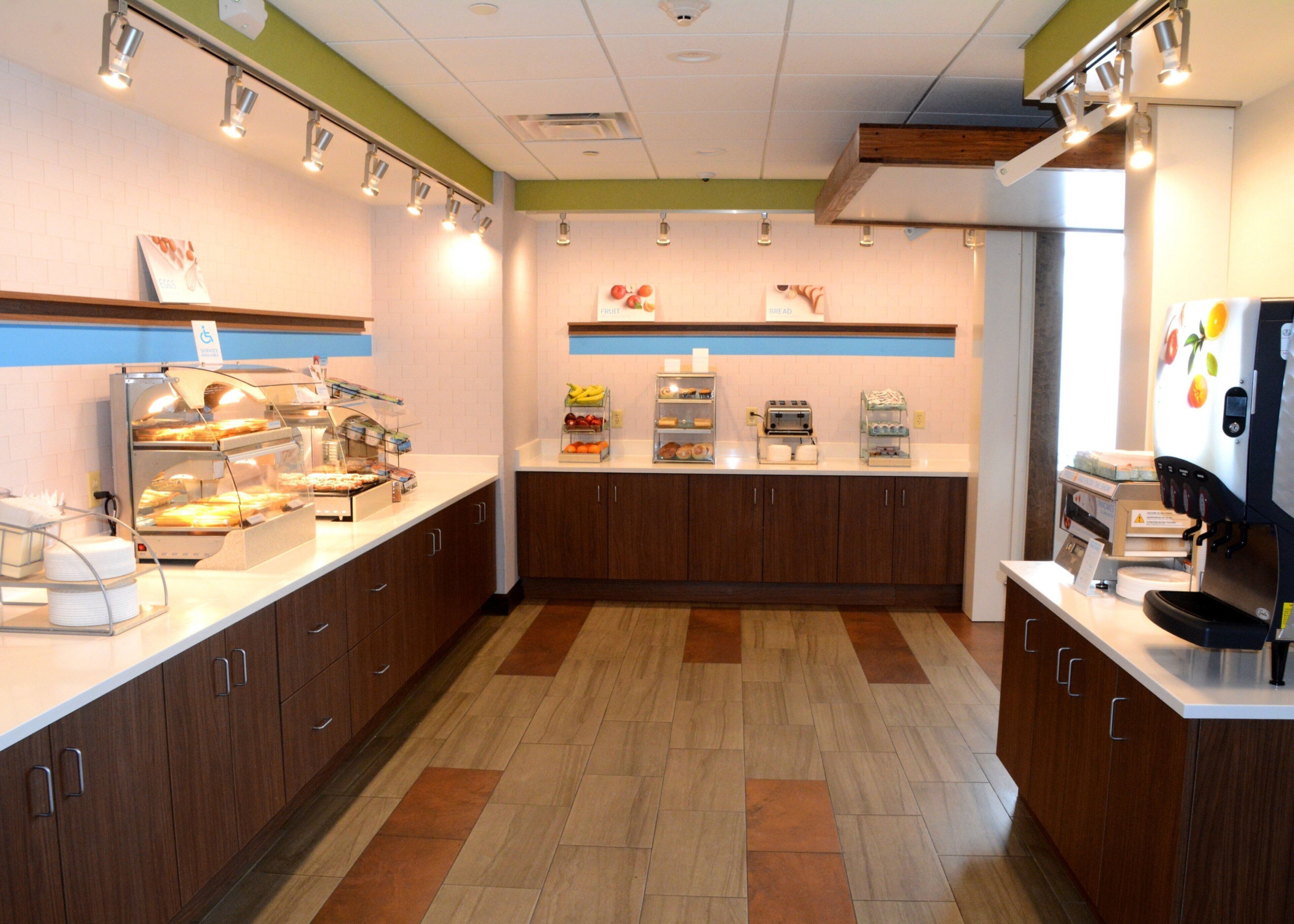 Un café moderno con barra de desayuno tipo buffet, máquina de café y diversas opciones gastronómicas.