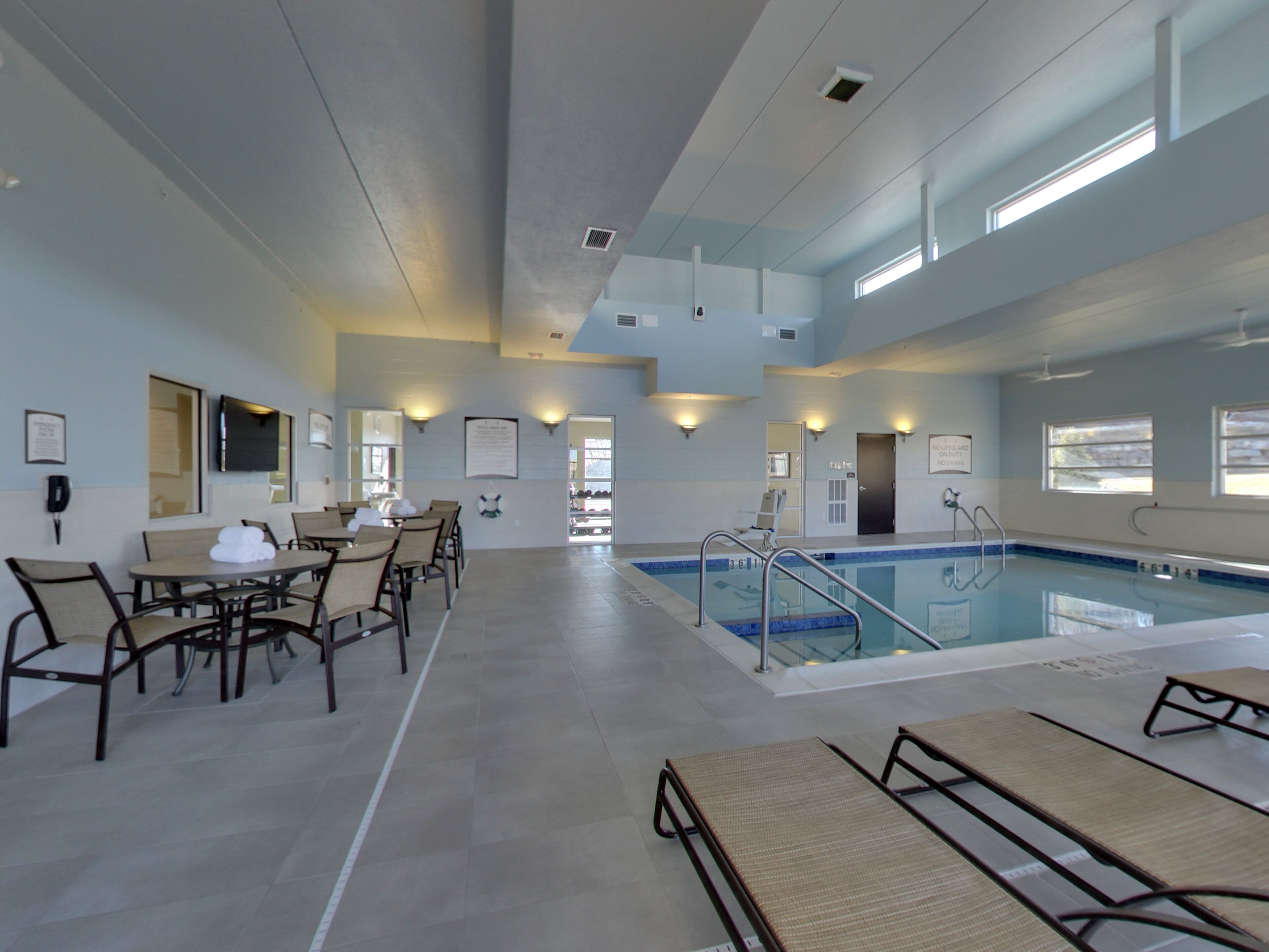 A hotel lobby with a pool, seating area, and a reception desk.