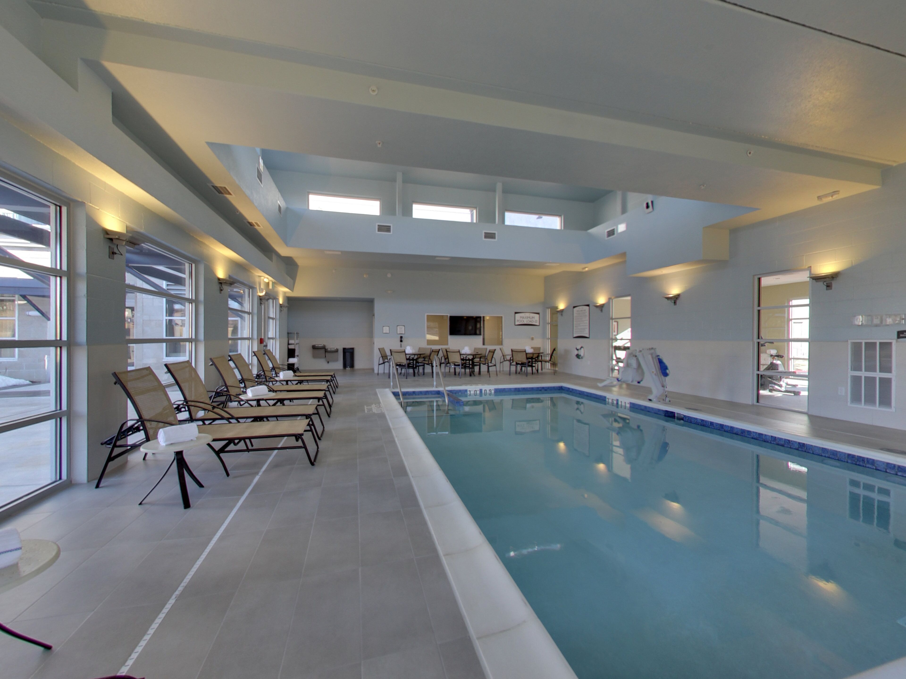 Una piscina techada, sillones reclinables de piscina